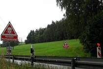 Heute am 05.07.2016 sah ich an der B85 bei Regen diese Warnschilder. Sie dienenen weniger dem durchfahrenden Verkehr sondern den durchfahrenden Baufahrzeugen also Bagger und Kipper mit ihren Arbeitsgeräten beim Straßenbau nicht an der 20000Volt führenden Stromleitung hängen zu bleiben