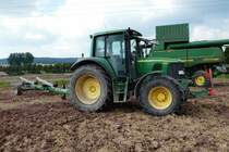 =John Deere 6320 transportiert das Schneidwerk des großen Mähdreschers im August 2016