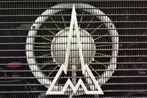 Magirus-Deutz Kühleremblem eines Haubenfahrzeugs. Bestehend aus dem M für Magirus und der Silhouette des Ulmer Münsters. Fotografiert in Bruchhausen-Vilsen im Mai 2015.