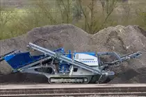  Raupenmobiler Kegelbrecher Mobicone MCO 9 S steht an einem Sammelplatz für Bauschutt.   März 17.