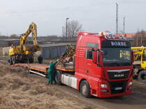 Verladung eines Zweiwegebagger`s,am 03.März 2017,auf einem MAN Schwerlasttransporter,auf einem Feldweg beim Bahnhof in Bergen/Rügen.