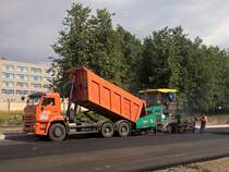 Straßenbau in Kolpino, KAMAZ-Kipper belädt Vögele-Super-1900-2 Teermaschine, 6.8.17