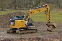 . Caterpillar 320E L RR Raupenbagger steht abseits von der Straße an einer Baustelle.  03.2018