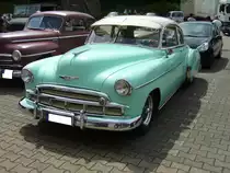 Chevrolet Series 2100 HK Styleline DeLuxe Sport Coupe aus dem Modelljahr 1950. Die Modelle der Series 2100 HK DeLuxe waren die Modelle mit der gehobeneren Ausstattung in diesem Modelljahr. Von dieser Ausstattungs- und Karosserieversion verkaufte Chevrolet im Jahr 1950 81.536 Fahrzeuge zu einem Preis ab US$ 1498,00. Angetrieben wird der Wagen serienmäßig von einem Sechszylinderreihenmotor, der aus 3546 cm³ Hubraum 90 PS leistet. Mit 1.520.583 produzierte PKW war Chevrolet 1950 der größte Automobilhersteller der Welt. Oldtimertreffen Nordsternpark Gelsenkirchen am 24.06.2018.