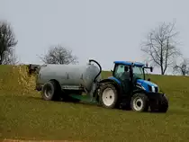 NEW-HOLLAND TS110A verbreitet mit dem Güllefass entsprechend flüssigen Dünger sowie ein paar Geruchsmomente entlang der Frühlingslandschaft; 180310