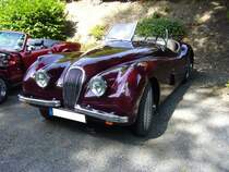 Jaguar XK120. 1948 - 1954. Hier wurde ein XK120 OTS abgelichtet. Das OTS steht für O pen T wo S eater. Im Laufe der Produktionszeit kam noch das Modell FHC und DHC hinzu. Der in maroon red lackierte XK120 entstammt dem Baujahr 1952. Er hat einen 6-Zylinderreihenmotor, der aus 3442 cm³ Hubraum 180 PS leistet. Je nach Achsübersetzung soll die Höchstgeschwindigkeit zwischen 180 km/h und 210 km/h liegen. Oldtimertreffen  Schwarzwaldhaus  in Mettmann am 12.08.2018.