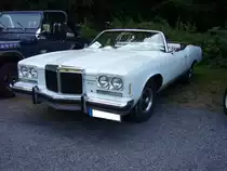 Pontiac Grand Ville Convertible des Modelljahres 1974. Von diesem Modell verkaufte die GM- Division Pontiac im Jahr 1974 genau 3000 Fahrzeuge. Das in cameo white lackierte Cabriolet hat einen V8-motor mit einem Hubraum von 7473 cm³ und leistet 215 PS. Mit dieser Leistung kann der Wagen eine Höchstgeschwindigkeit von 190 km/h erreichen. Laut Angabe des Eigentümers laufen dann aber auch bis zu 36 Liter Kraftstoff auf 100 km durch den Vierfachvergaser der Marke Rochester-Quadrajet. Oldtimertreffen  Schwarzwaldhaus  in Mettmann am 12.08.2018.