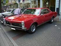 Pontiac GTO Coupe aus dem Modelljahr 1967 im Farbton regimental red. Im Jahr 1966 konnte der interessierte Kunde zwischen zwei V8-motoren wählen: 6361 cm³ Hubraum mit 335 PS Leistung oder 365 PS Leistung. Der GTO war als Convertible (Cabriolet) oder Coupe (Foto) lieferbar. 10. Dukes of Downtown am 01.09.2018 in Essen-Rüttenscheid.