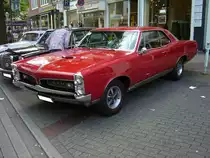 Pontiac GTO Coupe aus dem Modelljahr 1967 im Farbton regimental red. Im Jahr 1966 konnte der interessierte Kunde zwischen zwei V8-motoren wählen: 6361 cm³ Hubraum mit 335 PS Leistung oder 365 PS Leistung. Der GTO war als Convertible (Cabriolet) oder Coupe (Foto) lieferbar. 10. Dukes of Downtown am 01.09.2018 in Essen-Rüttenscheid.