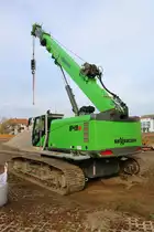 Sennebogen 643E Rauppenkran am 10.11.18 in Bad Vilbel durch den Zaun fotografiert