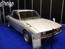 Isuzu 117 aus dem Modelljahr 1981. Das Modell 117 kam im Jahr 1966 auf den Markt. Die  Limousine und das Kombimodell nannten sich Isuzu Florian. Die Baureihe wurde permanent technisch und optisch weiter entwickelt. Im Jahr 1981 kam das Aus für diese Modellreihe. Der abgelichtete Wagen entstammt somit dem letzten Produktionsjahr. Das Coupe konnte mit vier Motorisierungen bestellt werden: Vierzylinderreihenmotor mit einem Hubraum von 1818 cm³ und 110 PS, Vierzylinderreihenmotor mit einem Hubraum von 1950 cm³ und einer Leistung von 115 PS oder 120 PS mit Benzineinspritzung. Die Spitzenmotorisierung war allerdings der Vierzylinderreihenmotor mit 1950 cm³ Hubraum und zwei oben liegenden Nockenwellen und einer Leistung von 135 PS. Essen-Motor-Show am 04.12.2018.