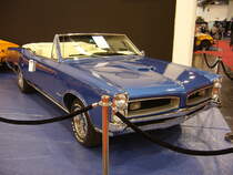 Pontiac GTO Convertible des Modelljahres 1966. Das Modell GTO war von 1964 bis 1974 eine eigenständige Modellreihe im Verkausprogramm von Pontiac. Der Wagen war als Coupe oder Convertible lieferbar. Von diesem Cabrioletmodell verkaufte Pontiac im Jahr 196612.798 Fahrzeuge zum Preis ab US$ 3425,00. Der V8-Motor hat einen Hubraum von 6361 cm³ und konnte wahlweise mit einem Doppelvergaser = 340 PS oder drei Doppelvergasern = 365 PS bestellt werden. Der abgelichtete GTO ist im Farbton fontaine blue lackiert. Essen-Motor-Show am 04.12.2018. 