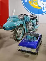 Motorrad mit Beiwagen (Aufschrift  I Sch  für das Moskwitsch-Zweigwerk Ischmasch) und ein Tretauto in der Retro Car Show im Einkaufszentrum  Piterlend  in St. Petersburg, 17.2.18