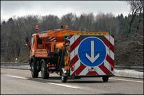 Der MAN LE10.220 beschleunigt mit der fahrbaren Absperrtafel in Richtung L�denscheid. (24.02.2009)
