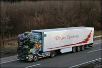 DIE WIEGE DER MENSCHEIT: Der SCANIA TOPLINE R500 der Spedition R�tzen pr�sentiert mit Herpa  WELTGESCHICHTE Nr.1  DIE WIEGE DER MENSCHEIT . Hier am 03.03.2009 ist die pr�chtige Zugmaschine durch das Sauerland in Richtung Ruhrgebiet unterwegs. Uhrspr�nglich hatte die Zugmaschine eine Sidepipe und war f�r die Spediton  J�rgen Schmid Transporte  unterwegs.
