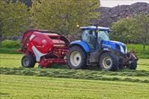 New Holland T7 Traktor mit einer Lely Rundballenpresse, aufgenommen beim Heupressen. Mai 2019 
