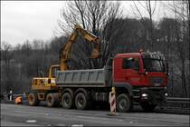 Ein Mobilbagger von KOMATSU l�dt die verschiedenen Tragschichten der Fahrbahn und das Erdreich in den MAN TGA 26.430 D20 CommonRail. (16.03.2009)
