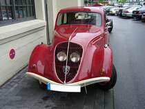 Peugeot 202 Limousine. Als Basismodell brachte man in Sochaux im Januar 1938 den Peugeot 202 auf den Markt. Das Modell war als Cabriolet, Limousine und Lieferwagen lieferbar. Bedingt durch WW2 wurde die Produktion 1940 eingestellt. Ab 1946 wurde das Modell wieder produziert. Der abgelichtete 202 stammt aus dem Modelljahr 1948. Der Vierzylinderreihenmotor hat einen Hubraum von 1133 cm³ und leistet 30 PS. Die Höchstgeschwindigkeit gab man bei Peugeot mit 100 km/h an. Besucherparkplatz der Düsseldorfer Classic Remise im Jahr 2009.