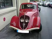 Peugeot 202 Limousine. Als Basismodell brachte man in Sochaux im Januar 1938 den Peugeot 202 auf den Markt. Das Modell war als Cabriolet, Limousine und Lieferwagen lieferbar. Bedingt durch WW2 wurde die Produktion 1940 eingestellt. Ab 1946 wurde das Modell wieder produziert. Der abgelichtete 202 stammt aus dem Modelljahr 1948. Der Vierzylinderreihenmotor hat einen Hubraum von 1133 cm³ und leistet 30 PS. Die Höchstgeschwindigkeit gab man bei Peugeot mit 100 km/h an. Besucherparkplatz der Düsseldorfer Classic Remise im Jahr 2009.