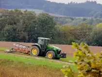 JD-7720 mit Acckergerätschaft in hügeliger Landschaft des Innviertels; 191003