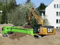 Cat 324 E LN Raupenbagger belud am 23.04.2020 in Berlin einen Mercedes Benz Kippsattellastzug.