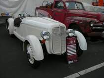 Adler Trumpf Junior Sport Cabriolet aus dem Jahr 1937. Der Adler Trumpf wurde 1934 vorgestellt. Ein Jahr später präsentierten die Frankfurter Adler-Werke das Sport-Cabriolet. Dieses Modell war bis 1937 im Verkaufsprogramm von Adler. Der Wagen konnte mit zwei Motorisierungen bestellt werden. Beide Motorisierungen erfolgten durch einen Vierzylinderreihenmotor mit einem Hubraum von 995 cm³. Der Basismotor leistete 25 PS bei einem Kaufpreis von RM 3750,00 (1937). Der Wagen mit dem stärkeren Motor leistete 28 PS und kostete RM 4150,00 (1937). Eine Besonderheit waren die mitlenkenden vorderen Kotflügel. Außengelände der Techno Classica Essen am 09.04.2016. 