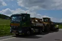 Mercedes Benz Sattelzug hat am Stra�enrand angehalten um die Forstmaschine abzuladen. 20.07.2020