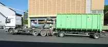 =.... hakt den auf den Anhänger befindlichen Container ein und zieht ihn Richtung Motorwagen.