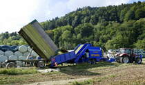LT-Master bei der Arbeit,kompletter Arbeitsvorgang im Bild, links Anlieferung von Maishäcksel, per Förderband in die Rundballenpresse, dann einwickeln in Folie und seitlich auswerfen, rechts der Zapfwellenantrieb durch den Traktor, Sept.2020