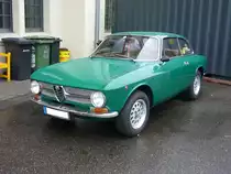 Alfa Romeo GT 1300 Junior im Farbton verde muschio, gebaut von 1966 bis 1970. Die GT oder auch Sprint genannten Modelle waren die zweitürige Coupeversion der bereits 1962 vorgestellten Giulia. Der Vierzylinderreihenmotor mit einem Hubraum von 1.290 cm³ leistet 89 PS. Im Jahr 1970 erfuhr das Coupe ein Facelift. Die Modelle vor diesem Facelift werden aufgrund der etwas abgesetzten Motorhaube auch  Kantenhauber  genannt. Besucherparkplatz der Düsseldorfer Classic Remise am 03.10.2020.