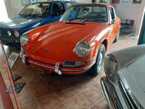 Porsche 912, gebaut von 1965 bis 1969. Porsche stellte 1965 die Produktion des 356´er ein. Um auch weniger finanzkräftigen Kunden weiterhin einen Porsche anbieten zu können, wurde der Vierzylinderboxermotor des 356C in die 911 Karosserie verpflanzt. Hier leistet der Motor 90 PS aus einem Hubraum von 1582 cm³. Bei seiner Markteinführung schlug ein solcher 912 mit einem Kaufpreis von mindestens DM 16.250,00 zu Buche, während man für den 911 schon mindestens DM 21.900,00 anlegen musste. Der gezeigte 912 wurde 1967 gebaut und ist im Farbton signalorange lackiert. Villacher Fahrzeugmuseum im Sommer 2019.