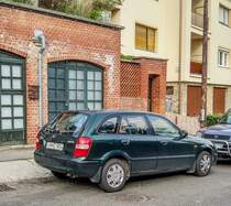 Rückansicht:_ Mazda 323 Hatchback in Juni, 2020.