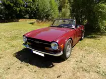 Triumph TR6 im Farbton carminered, produziert von 1970 bis 1975. Im Jahr 1970 erschien der letzte Abkömmling der legendären Triumph TR-Baureihe in Form des TR6. Die Karosserie hatte Giovanni Michelotti gezeichnet. Der Sechszylinderreihenmotor des TR6 stammt vom Triumph 2000 und wurde auf 2498 cm³ Hubraum aufgebohrt. Dieser Motor leistet 150 PS und beschleunigt den TR6 auf eine Höchstgeschwindigkeit von 190 km/h. Oldtimertreffen des Oldtimerclubs Schermbeck in Lühlerheim im Spätsommer 2018.