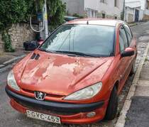 Orange Peugeot 206 mit Lackschaden, fotografiert in Juni 2020.