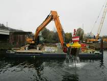 HYUNDAI HX 300L Kettenbagger auf einem Ponton auf der Berliner Spree beim  Ziehen  einer Sperrtonne im November 2020.