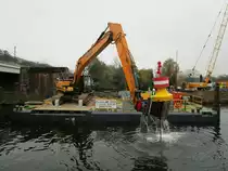 HYUNDAI HX 300L Kettenbagger auf einem Ponton auf der Berliner Spree beim  Ziehen  einer Sperrtonne im November 2020.
