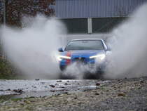  Nasses Fotoshooting . Ein Alfa Romeo Stelvio fährt durch eine große Pfütze, aufgenommen am 25.12.2020