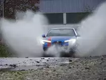  Nasses Fotoshooting . Ein Alfa Romeo Stelvio fährt durch eine große Pfütze, aufgenommen am 25.12.2020