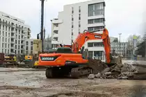 Doosan DX3000S am 24.01.21 in Frankfurt am Main durch den Bauzaun fotografiert von einen Gehweg aus 