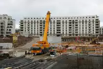 Schick Liebherr Autokran am 24.01.21 in Frankfurt am Main durch den Bauzaun fotografiert von einen Gehweg aus