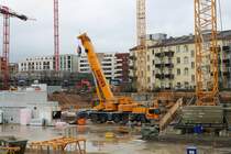 Schick Liebherr Autokran am 24.01.21 in Frankfurt am Main durch den Bauzaun fotografiert von einen Gehweg aus