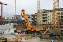Schick Liebherr Autokran am 24.01.21 in Frankfurt am Main durch den Bauzaun fotografiert von einen Gehweg aus