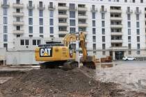 Kolb CAT 330F am 24.01.21 in Frankfurt am Main durch den Bauzaun fotografiert von einen Gehweg aus