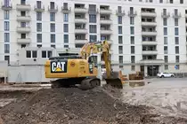 Kolb CAT 330F am 24.01.21 in Frankfurt am Main durch den Bauzaun fotografiert von einen Gehweg aus