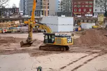 Kolb CAT 336E am 24.01.21 in Frankfurt am Main durch den Bauzaun fotografiert von einen Gehweg aus
