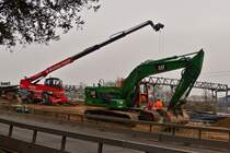 Raupenbagger Caterpillar 320 und Manitou Teleskoplader, aufgenommen an einer Straenbaustelle. 02.2021