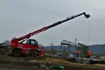 Manitou Teleskoplader hilft beim Positionieren einer Betonplatte. 02.2021
