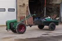 Holder Kleintraktor mit Hnger steht in einem Hof, von der Strae aus aufgenommen. 03.2021