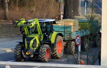 Ein CLAAS Traktor Typ? mit Hänger mit Heuballen am 24.03.21 Berlin Buch.