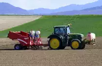 John Deere 6120, Allradschlepper, mit Kartoffellegemaschine Grimme GL bei der Feldarbeit, April 2021